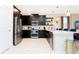 Modern kitchen featuring stainless steel appliances, dark cabinets, and a breakfast bar at 9312 Sommerset Hills Dr, Davenport, FL 33896