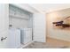 Functional laundry room with a washer, dryer, shelving, and an abstract art piece at 9312 Sommerset Hills Dr, Davenport, FL 33896