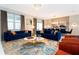 Stylish living room with plush blue sofas, decorative rug, and elegant lighting at 9312 Sommerset Hills Dr, Davenport, FL 33896