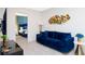 Comfortable living room with a blue velvet sofa, stylish decor, and a view into another bedroom at 9312 Sommerset Hills Dr, Davenport, FL 33896