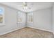 This bedroom features neutral walls, plush carpeting, and is brightly lit by a ceiling fan and natural light at 1013 Maiden Ter, Celebration, FL 34747