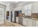 Open concept kitchen with granite countertops, stainless steel appliances, and white cabinetry at 1013 Maiden Ter, Celebration, FL 34747