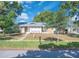 Charming single-story home with a brick facade, well-maintained lawn, and mature trees under a blue sky at 1030 Gran Paseo Dr, Orlando, FL 32825