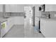 Modern white kitchen featuring stainless steel appliances and marble tile flooring at 1030 Gran Paseo Dr, Orlando, FL 32825