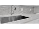 Close-up of stainless steel kitchen sink with modern faucet and tiled backsplash at 1030 Gran Paseo Dr, Orlando, FL 32825