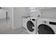 This laundry room is bright and features modern appliances, marble tile flooring, and a sink at 1030 Gran Paseo Dr, Orlando, FL 32825