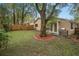 The backyard features a well-maintained lawn, a large tree for shade, and a barbecue grill at 1105 Mill Run Cir, Apopka, FL 32703