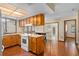 Well-lit kitchen featuring wood cabinets, white appliances, and hardwood floors at 1105 Mill Run Cir, Apopka, FL 32703