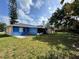 View of the home's backyard showcasing an expansive lawn, the home's exterior, and a chimney at 132 Acapulco Dr, Kissimmee, FL 34743