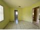 Bedroom featuring tile flooring, yellow walls, and natural light from the window at 132 Acapulco Dr, Kissimmee, FL 34743