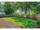 Well-maintained backyard with a wooden fence, green lawn, mulch, and lush landscaping at 1424 W New Hampshire St, Orlando, FL 32804