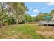 Expansive backyard featuring a wooden deck, lush greenery, and mature trees draped with Spanish moss at 150 Debary Dr, Debary, FL 32713