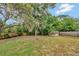 Large backyard with mature trees, shed, and a wood privacy fence at 150 Debary Dr, Debary, FL 32713