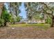 Backyard features mature trees, shed, fenced yard, and generous lawn at 150 Debary Dr, Debary, FL 32713