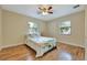 Bright bedroom with hardwood floors, two windows, and a ceiling fan at 150 Debary Dr, Debary, FL 32713
