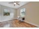 Cozy bedroom features two windows for natural light, ceiling fan and wood-look flooring at 150 Debary Dr, Debary, FL 32713