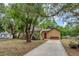 Landscaped front yard of a single-story home showcasing a healthy lawn, mature shade trees, and a vibrant garden at 150 Debary Dr, Debary, FL 32713