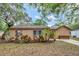Charming single-story home featuring a well-manicured front yard with lush landscaping and mature trees at 150 Debary Dr, Debary, FL 32713