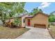 Inviting single-story home with a lush front yard, featuring a red front door and mature trees at 150 Debary Dr, Debary, FL 32713