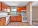 Kitchen featuring wood cabinets, granite countertops, tile flooring, and white appliances at 150 Debary Dr, Debary, FL 32713