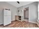 Compact kitchenette with sink, cabinet storage, shelving, white appliances, and stylish wood flooring at 150 Debary Dr, Debary, FL 32713