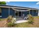 Back patio with seating area and sunshade, accessible via sliding glass doors, on a sunny day at 1671 Judith Dr, Kissimmee, FL 34758