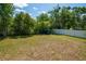 Backyard with a large grassy lawn, a storage shed, and a privacy fence, surrounded by mature trees at 1671 Judith Dr, Kissimmee, FL 34758