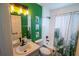 Bathroom with white shower curtain, green walls, vanity sink, and toilet at 1671 Judith Dr, Kissimmee, FL 34758