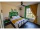 Cozy bedroom with a black metal bed frame, complemented by green accents and a natural light-filled window at 1671 Judith Dr, Kissimmee, FL 34758