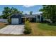 Charming single-story home with a well-manicured lawn, attached garage, and blue exterior paint at 1671 Judith Dr, Kissimmee, FL 34758