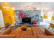 Open living room with vibrant accents, including a tropical mural, yellow accents, and modern furniture at 1671 Judith Dr, Kissimmee, FL 34758
