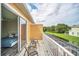 Sunny balcony featuring tile floors and serene views overlooking the green landscape and neighboring pool at 17349 Serenidad Blvd, Clermont, FL 34714