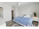 Bright bedroom with a large white tufted headboard bed, ceiling fan and plank flooring at 17349 Serenidad Blvd, Clermont, FL 34714