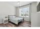 Serene bedroom with minimalist decor, a large window, and hardwood floors for a peaceful retreat at 17349 Serenidad Blvd, Clermont, FL 34714