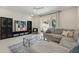 Inviting living room with plush gray sofa, entertainment center, and view of the pool area at 17349 Serenidad Blvd, Clermont, FL 34714