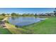 Pond view from edge of community with manicured lawn at 17349 Serenidad Blvd, Clermont, FL 34714