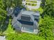 Aerial view of home with dark roof, solar panels and a screened pool, surrounded by lush landscaping at 1761 Legion Dr, Winter Park, FL 32789