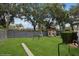 This spacious backyard features a playset, green grass, mature trees, and a gray privacy fence at 1761 Legion Dr, Winter Park, FL 32789
