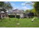 This spacious backyard features a playset, hedges, a screen enclosure, and lush green grass at 1761 Legion Dr, Winter Park, FL 32789