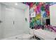 This modern bathroom features gemstone-themed wallpaper, a glass-enclosed shower, and a floating sink at 1761 Legion Dr, Winter Park, FL 32789