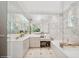 This spacious bathroom includes marble walls, a soaking tub, crystal chandeliers, and plenty of counter space at 1761 Legion Dr, Winter Park, FL 32789