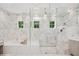 This bathroom features marble walls, a glass-enclosed shower, a soaking tub, and several windows at 1761 Legion Dr, Winter Park, FL 32789