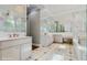 A luxurious bathroom boasts marble walls and floors, mirrored wall, dual sinks and modern lighting at 1761 Legion Dr, Winter Park, FL 32789