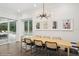 Bright dining room features modern light fixture, art and a large table with seating for Gathering and guests at 1761 Legion Dr, Winter Park, FL 32789