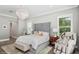 This main bedroom boasts a tufted headboard, chandelier, neutral tones, and plenty of natural light at 1761 Legion Dr, Winter Park, FL 32789