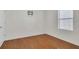 A vacant bedroom, showing the wood flooring, a double hung window, and empty wall space at 1866 Cassidy Knoll Dr, Kissimmee, FL 34744