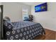 Cozy bedroom features a large television, window and rich wood floors at 1866 Cassidy Knoll Dr, Kissimmee, FL 34744