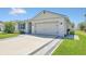 Spacious driveway featuring decorative pavers lining the edges, leading to a two-car garage and the home's entrance at 1866 Cassidy Knoll Dr, Kissimmee, FL 34744
