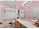 Bright bathroom with pink walls features a vanity and shower with patterned curtain at 1868 Rachels Ridge Loop # L, Ocoee, FL 34761