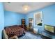 Bright blue bedroom with a patterned bedspread, TV, and practical storage shelves at 1868 Rachels Ridge Loop # L, Ocoee, FL 34761